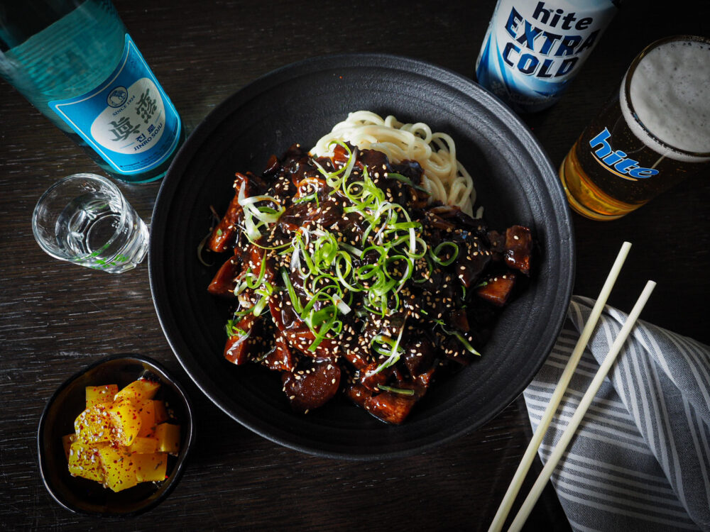 JJ Noodles, a dish of thick wheat noodles covered in a black bean paste sauce with pork and vegetables, and plentiful beer and soju. (Photo courtesy of Perilla: Korean American Fare)