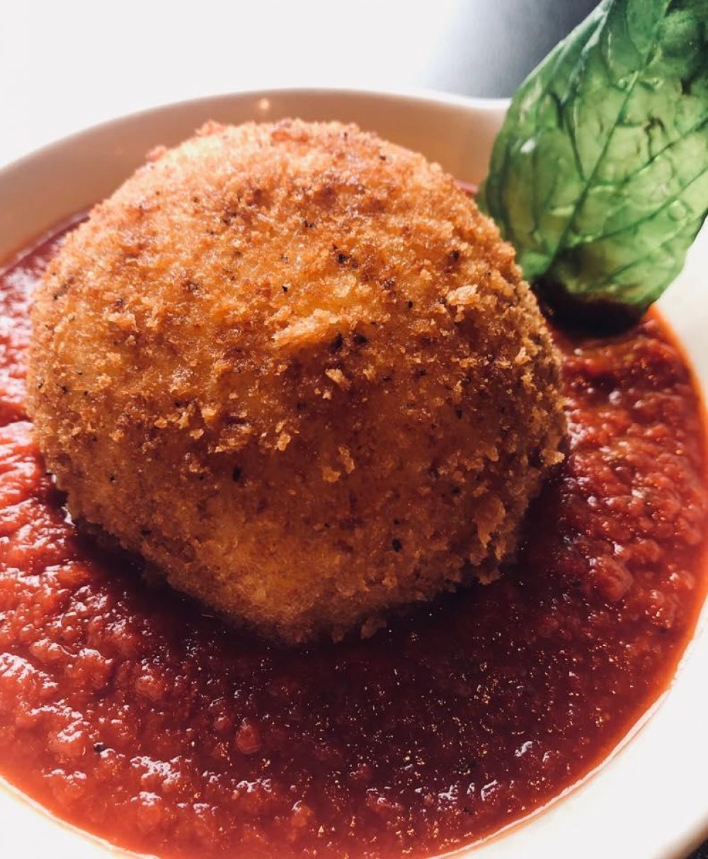 Arancini Fried Risotto Stuffed With Peas Pecorino And Ground Beef Over Marinara