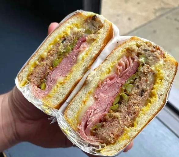 The new Cubano Sandwich at Daisies is loaded up with Catalpa Ham, Pork Confit, House Pickles and Griddled Ciabatta. (Photo courtesy of Daisies) for April Showers Bring Fun Food Events to the Calendar