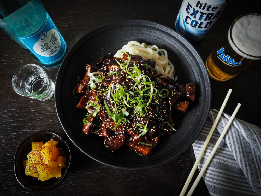 JJ Noodles, a dish of thick wheat noodles covered in a black bean paste sauce with pork and vegetables, and plentiful beer and soju. (Photo courtesy of Perilla: Korean American Fare) for April Showers Bring Fun Food Events to the Calendar