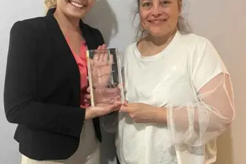 Hannah Rose Higdon And Sarah Stegner Accepting Award 1500 for Prairie Grass Cafe Honored for its Sensory Friendly Hour Program