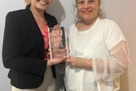 Hannah Rose Higdon And Sarah Stegner Accepting Award 1500 for Prairie Grass Cafe Honored for its Sensory Friendly Hour Program