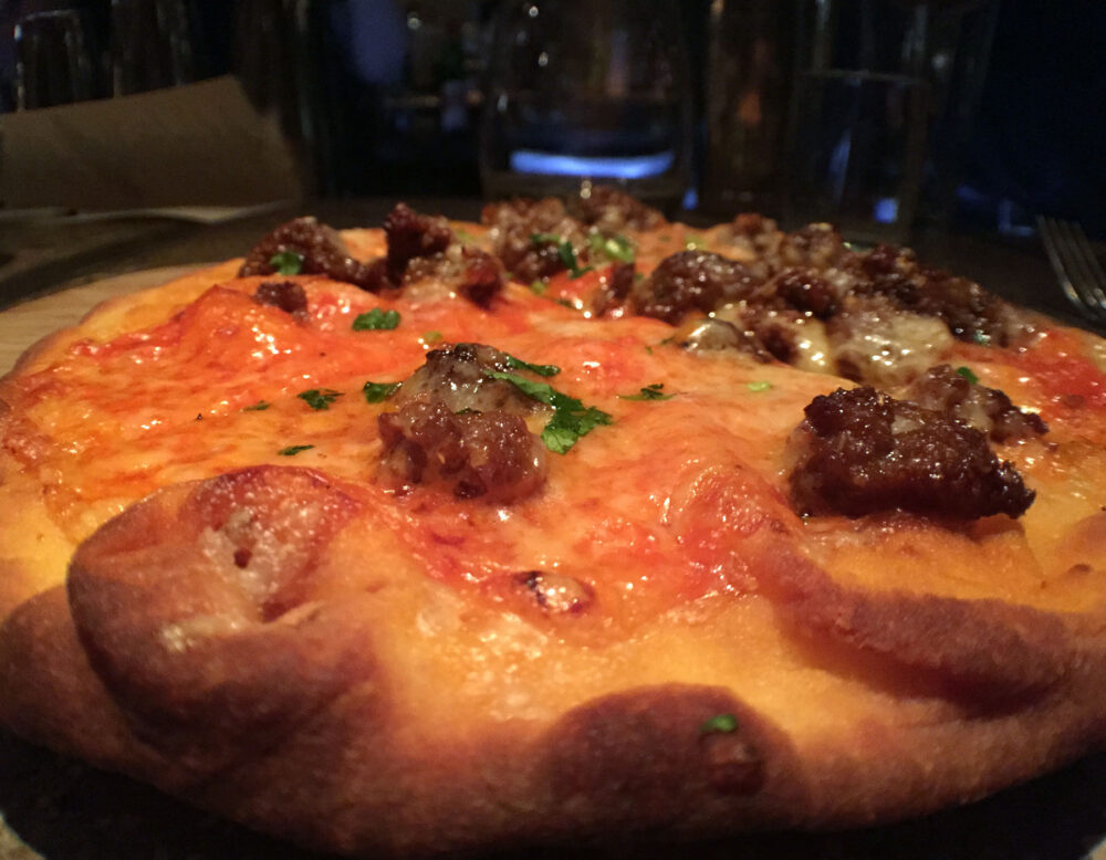 Flatbread with housemade merquez sausage, beecher's flagship cheese and piquillo pepper sauce for Ada Street's Restaurant Week Menu Finds Inspiration in Famous Last Meals