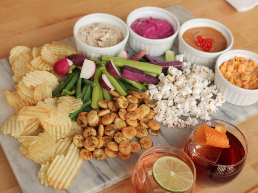 A salty feast of snacks pair perfectly with any Present Tense cocktail! P.S. the Ranch Snacker Crackers are a must! (Photo Courtesy of Present Tense) for CFM Asks: Derek Mercer, Founder of Recently Launched Ghost Bar, ‘Present Tense’