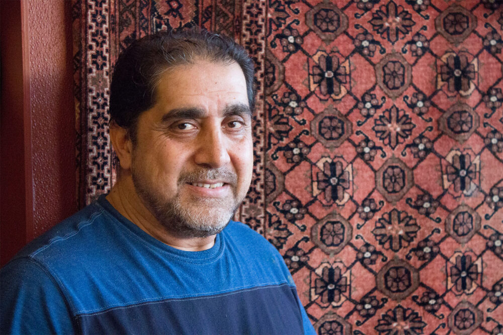 Nasir Raufi, owner of Albany Park’s Afghan Kabob, in front of one of several traditional carpets in his restaurant. Photo: Sarah Conway. for Where Chicago and Afghanistan Meet: Albany Park's Afghan Kabob Serves More than Dumplings