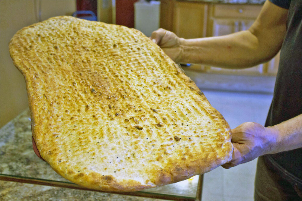 Nasir holds freshly baked bread. Photo: Sarah Conway. for Where Chicago and Afghanistan Meet: Albany Park's Afghan Kabob Serves More than Dumplings